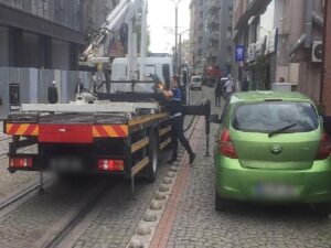 Tramvay yoluna park edilen araçlar çekiliyor